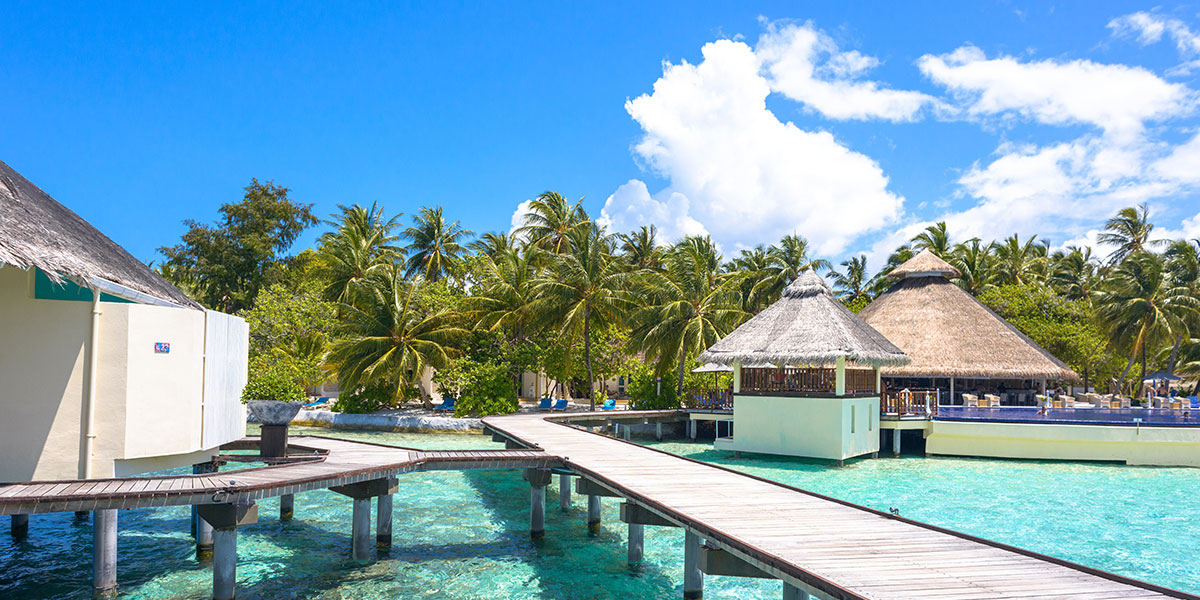 photo of maldives resort with huts and walkway on stilts